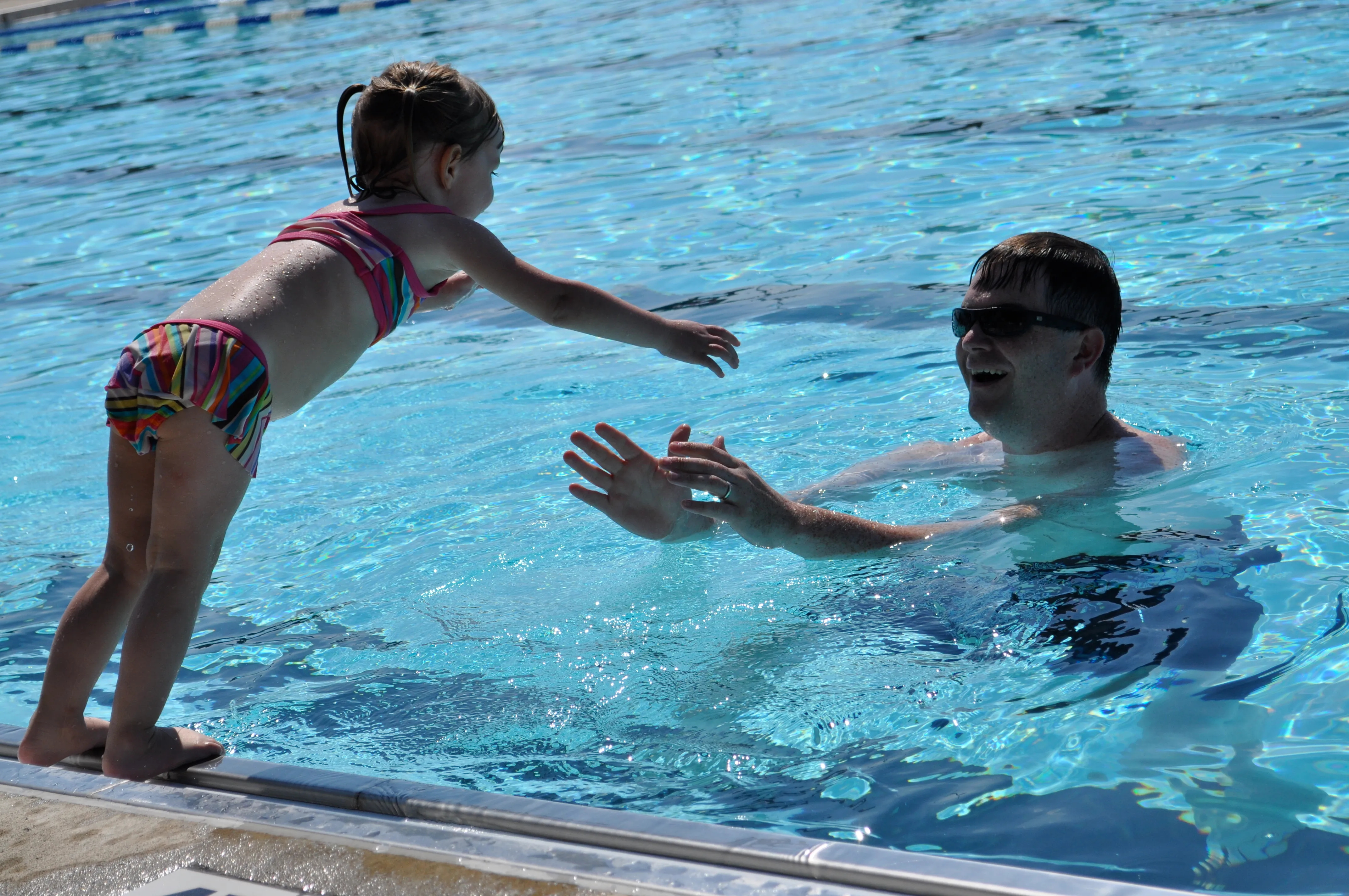 A two-year-old Allie leaping into the pool toward her dad at Spindletop in Lexington, Kentucky